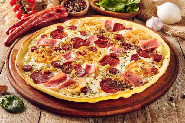 istock Meat and tomato pizza on wooden table close up 1191586159