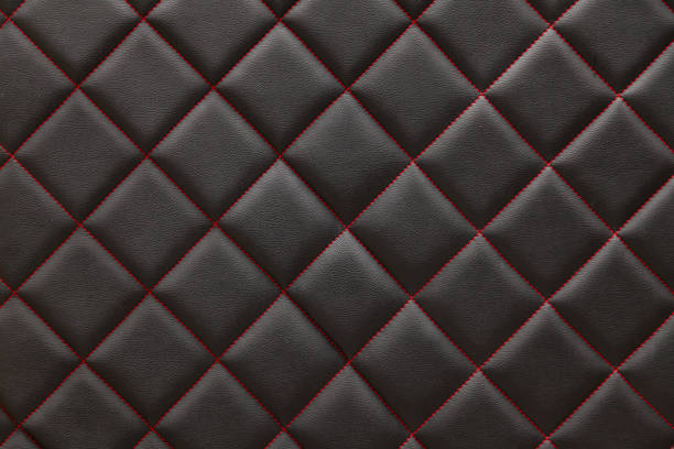 車両メンテナンスワークショップで車両のインテリアウエストのインテリアのパターンとして、赤いダイヤモンド形の糸でステッチされた黒い革の背景と質感。 - diamond shaped ストックフォトと画像