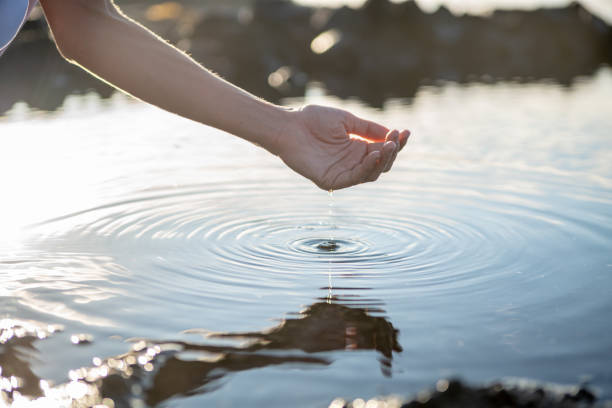 Human hand cupped to catch fresh water from sea pond in rocks Human hand cupped to catch fresh water from sea pond in rocks, Hawaii ripple water rippled lake stock pictures, royalty-free photos & images