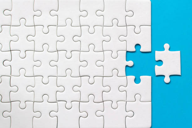 istock White jigsaw puzzle on blue background. Team business success partnership or teamwork 1191589156