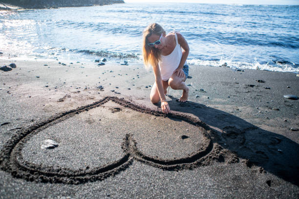 Drawing heart shape with footprints on the beach