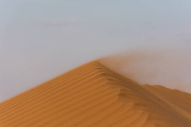 istock Sunset in the desert across a textured and patterned ridge with blowing sand making spectacular changing shapes. United Arab Emirates. Desert Concept. 1191590367