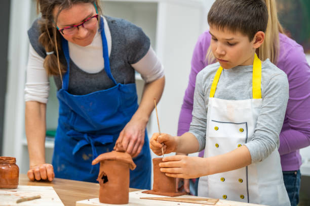 istock Boy making clay birdhouse in classroom 1191592238