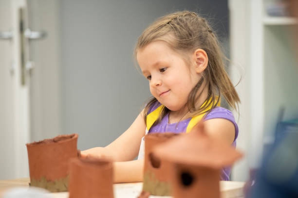istock Girl making clay birdhouse 1191592250