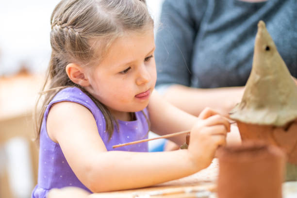 istock Girl making clay birdhouse 1191592251