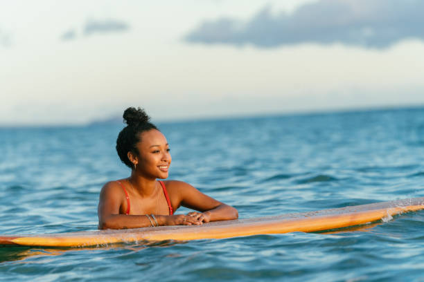 istock Young woman resting on her surfboard waiting for a wave 1191593337