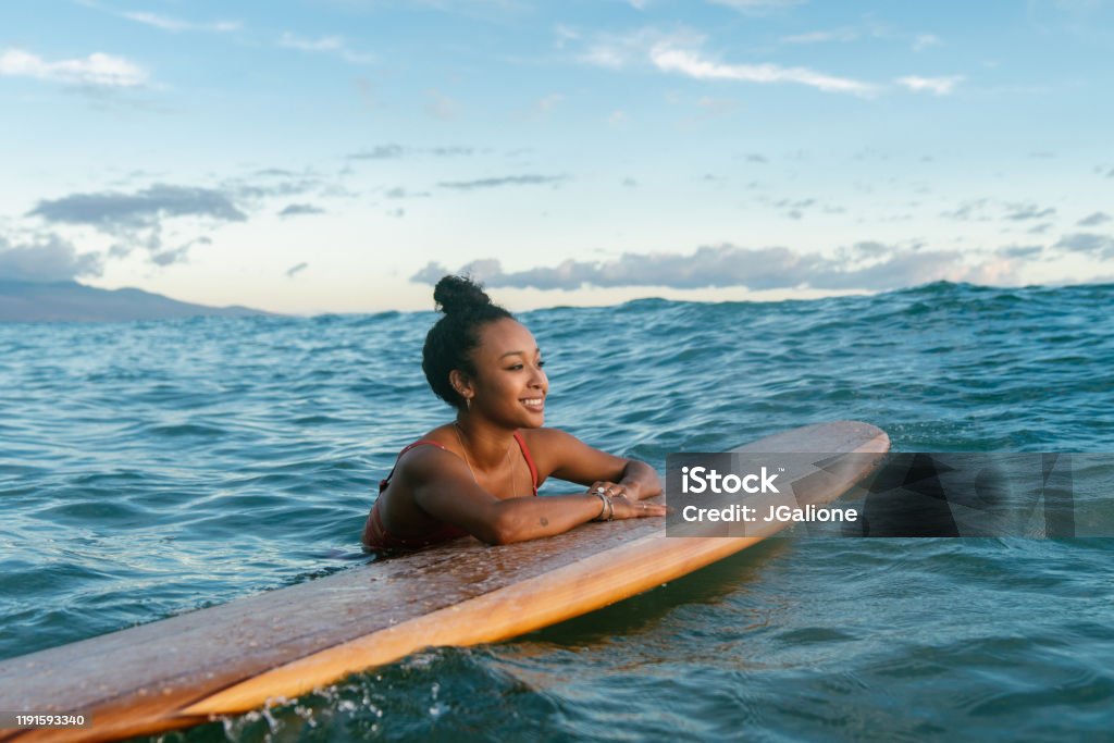 Young woman resting on her surfboard waiting for a wave Young woman resting on her surfboard waiting for a wave. Hawaii 2019 Hawaii Islands Stock Photo