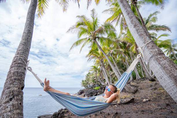 istock Girl relaxing on hammock hanging on palms by the beach 1191596502