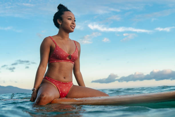 istock Young woman sitting on her surfboard waiting for a wave 1191597631