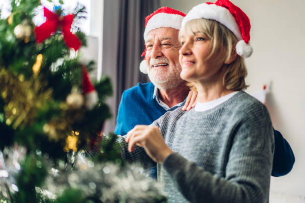 istock Romantic sweet senior couple relaxing  decorating christmas tree and smiling while celebrating new year eve and enjoying spending time together in christmas time at home 1191599088