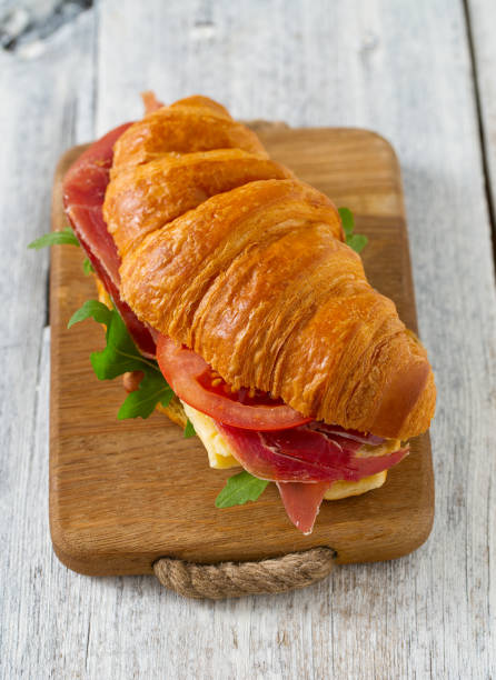istock croissants with argugula, jamon, cheese and tomato on wooden surface 1191600172