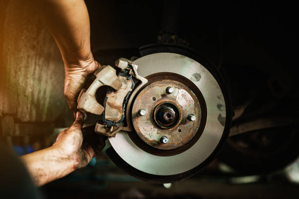 selective focus disc brake on car, in process of new tire replacement,car brake repairing in garage - travão imagens e fotografias de stock