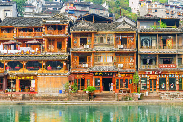 Scenic view of old traditional Chinese wooden riverside houses Fenghuang, China - September 23, 2017: Scenic view of old traditional Chinese wooden riverside houses in Phoenix Ancient Town (Fenghuang County). Fenghuang is a popular tourist destination of Asia. fenghuang county photos stock pictures, royalty-free photos & images