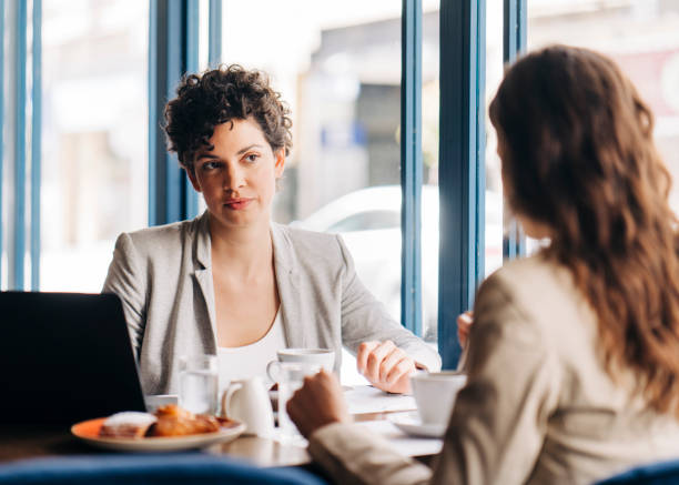 istock Female coworkers discussing at table in hotel 1191603600