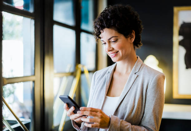 istock Businesswoman using smart phone in hotel 1191604827