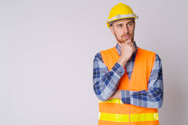 istock Portrait of young bearded man construction worker thinking and looking up 1191605826