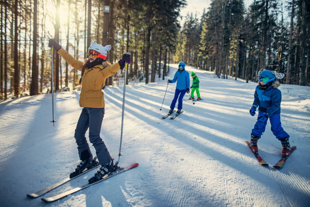 istock Family having fun skiing together on winter day 1191606113