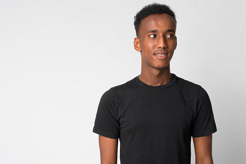 Studio shot of young handsome African man with Afro hair against white background