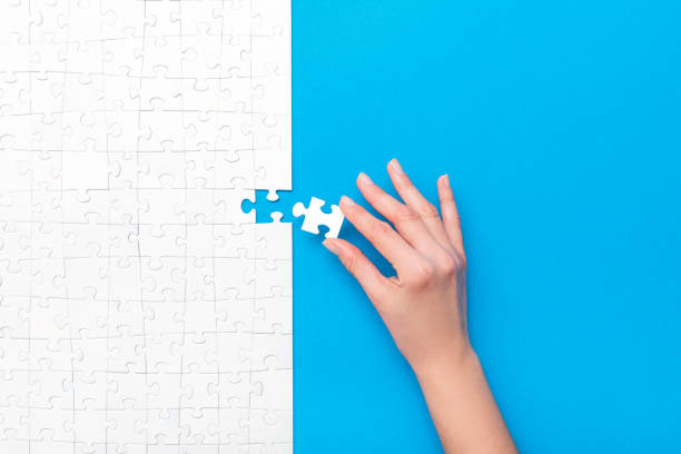 Business concept of white jigsaw puzzle. Hand put the last piece of jigsaw puzzle. Complete the mission. Business concept. jigsaw piece photos stock pictures, royalty-free photos & images
