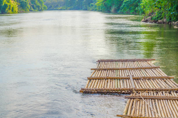 Old bamboo raft is floating on the river in the thailand