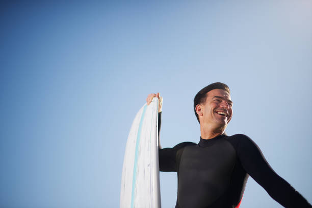 istock Smiling SUP man with Stand Up Paddle Board portrait with clear blue sky copy space 1191613468