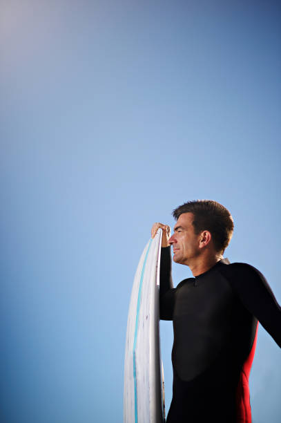 istock SUP man holding Stand Up Paddle Board portrait with clear blue sky copy space 1191613469