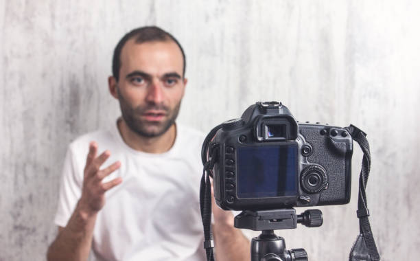 istock Camera on tripod is filming a man. Blogger 1191615967