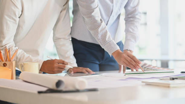 istock Cropped architect or engineer working in office with blueprints architectural closeup shot. 1191617163