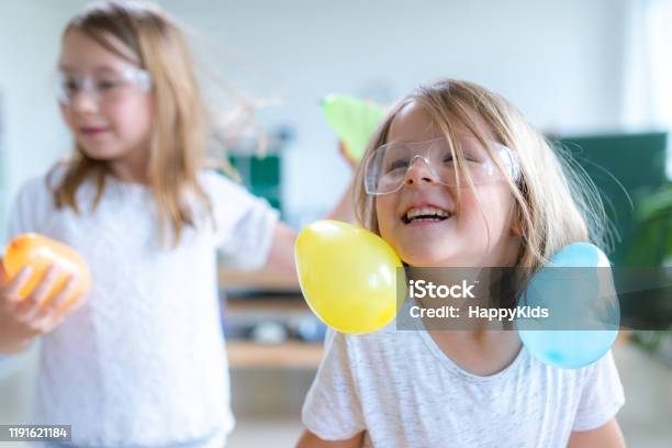 Students Doing Balloon Experiment Stock Photo - Download Image Now - Static Electricity, Balloon, Child
