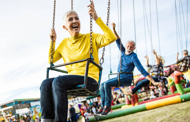 istock Happy seniors having fun while riding on chain swing at amusement park. 1191625005