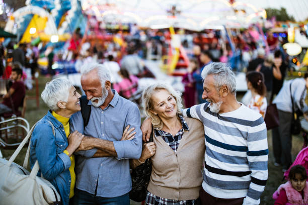 istock Happy mature couples talking while enjoying at amusement park. 1191625313