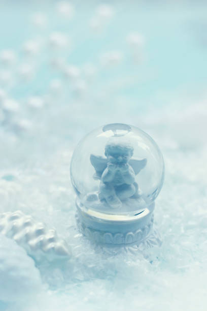 istock Small snow globe with angel figurine and snow; winter background with copy space 1191628330