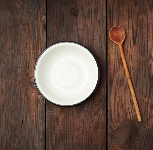 istock empty round metal white plate and wooden spoon on the table 1191628547