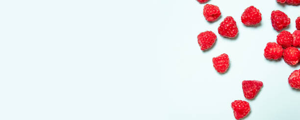 istock Top view and flat lay of fresh juicy raspberry berries on a blue background with copyspace 1191630006
