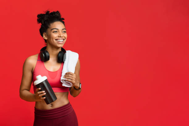 cheerful fitness girl drinking protein during exercising - beautiful one person strength sensuality imagens e fotografias de stock