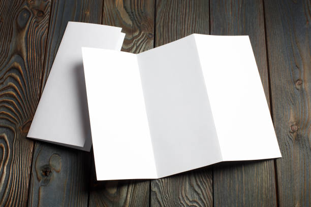 Folded sheets of white paper on wood