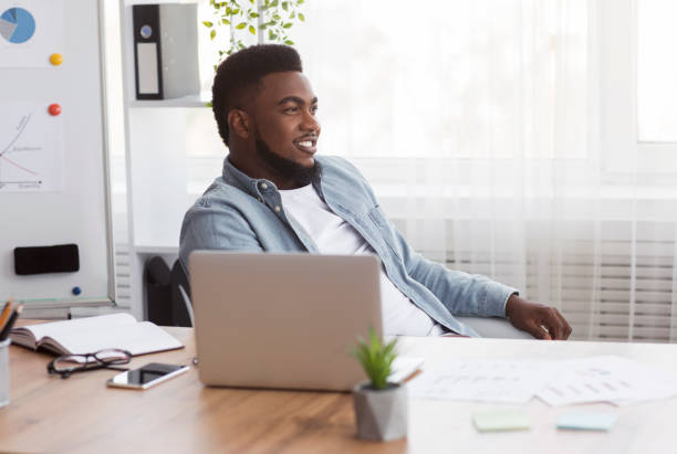 istock Successful black businessman sitting at workplace with glad face expression 1191633147