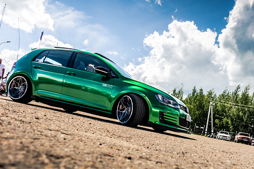 Moscow, Russia - July 06, 2019: Tuned Volkswagen Golf 7 tightened into a green vinyl film. Installed exclusive wheels, air suspension. Lowrider in the parking lot. Side view. Exclusive tuned golf 7 with extra wide rims