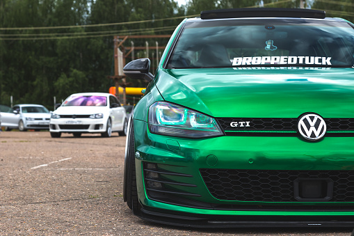 Moscow, Russia - July 06, 2019: Tuned Volkswagen Golf 7 tightened into a green vinyl film. Installed exclusive wheels, air suspension. Lowrider in the parking lot. front view Exclusive tuned golf 7 with extra wide rims