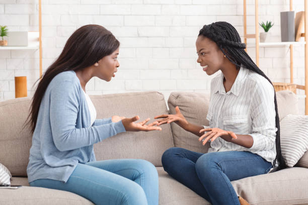 istock Two girlfriends sitting on sofa and arguing with each other 1191633497