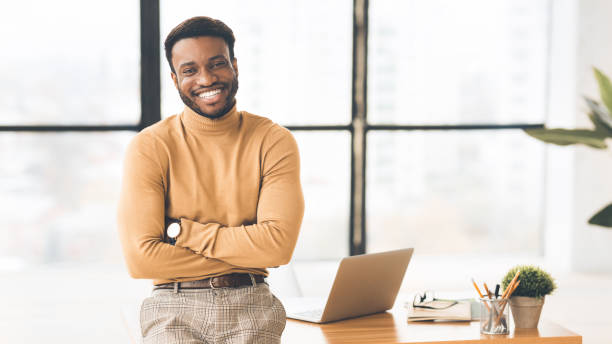 istock African businessman sitting on desk looking at camera 1191633740