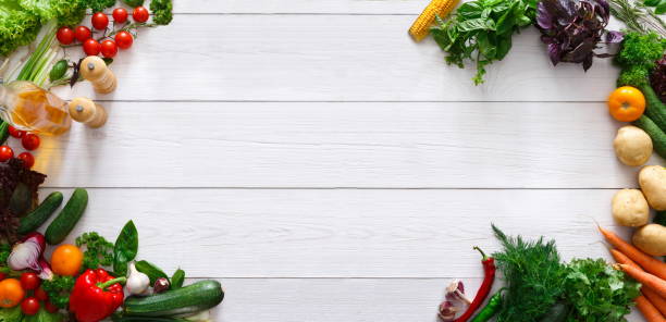 Frame of fresh organic vegetables with spices and oil Raw food diet banner. Frame of fresh organic vegetables with spices and oil on white wooden background, panorama with empty space leaf vegetable photos stock pictures, royalty-free photos & images