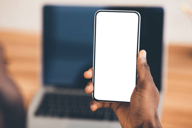 African american using black phone with blank screen Useful App. Close-up of black man holding mobile phone with white blank screen. Mock up, rear view hand holding phone stock pictures, royalty-free photos & images