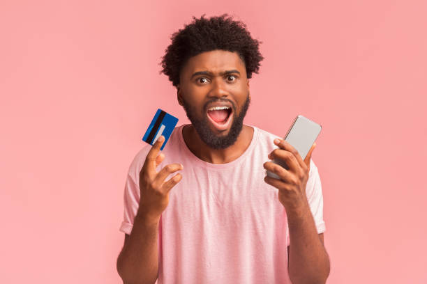istock Amazed man holding credit card, using cellphone for online shopping 1191634816