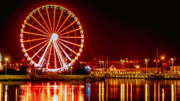 illuminations in the polish city of szczecin, ferris wheel at night - laser firework display performance showing imagens e fotografias de stock