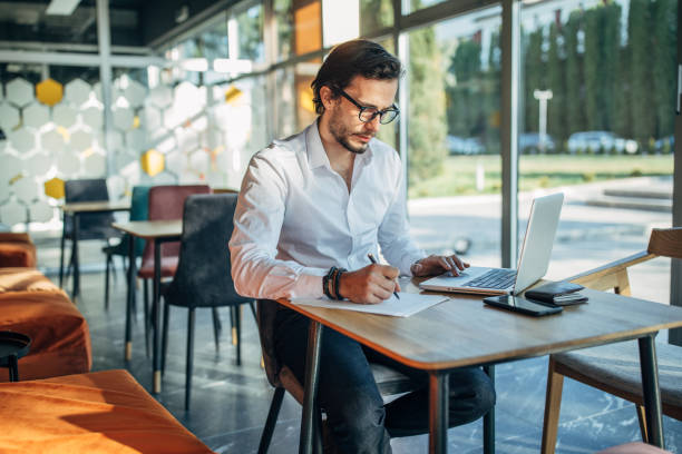 istock Young gentleman sitting in cafe and working 1191636205