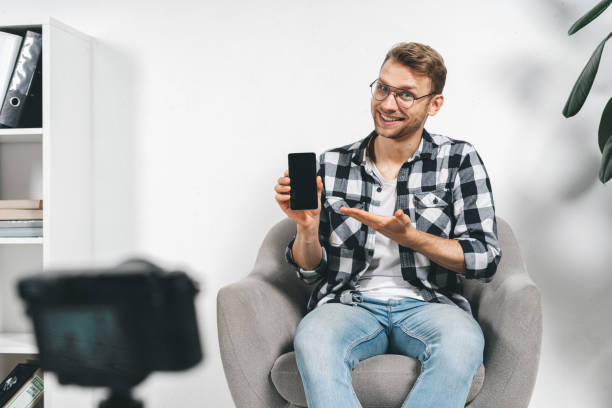 istock Young adult successful blogger using video camera, creative online content 1191636206