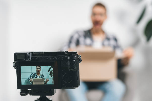istock Young adult successful blogger using video camera, creative online content 1191636254