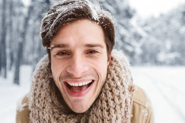istock Cheerful Young Man Smiling Looking At Camera In Snowy Forest 1191636261