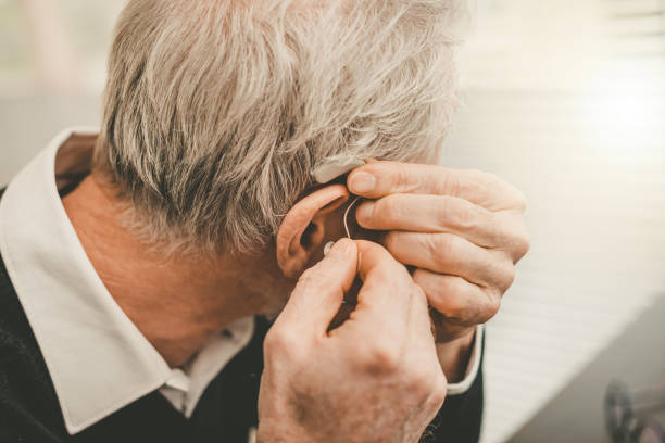 Man putting hearing aids stock photo